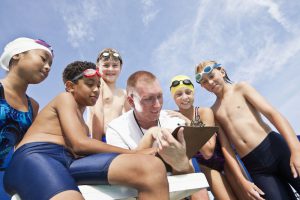 Coach reviewing data with students on an iPad